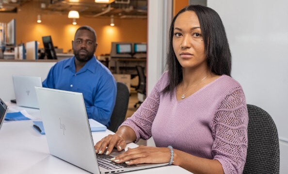 To medarbejdere, der arbejder på deres HP-laptops på deres kontor.